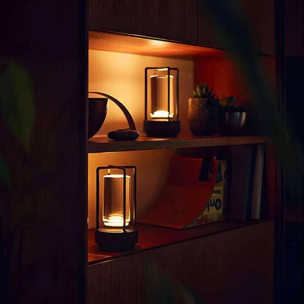 Two Nordic-style crystal table lanterns with warm ambient glow on a wooden shelf.