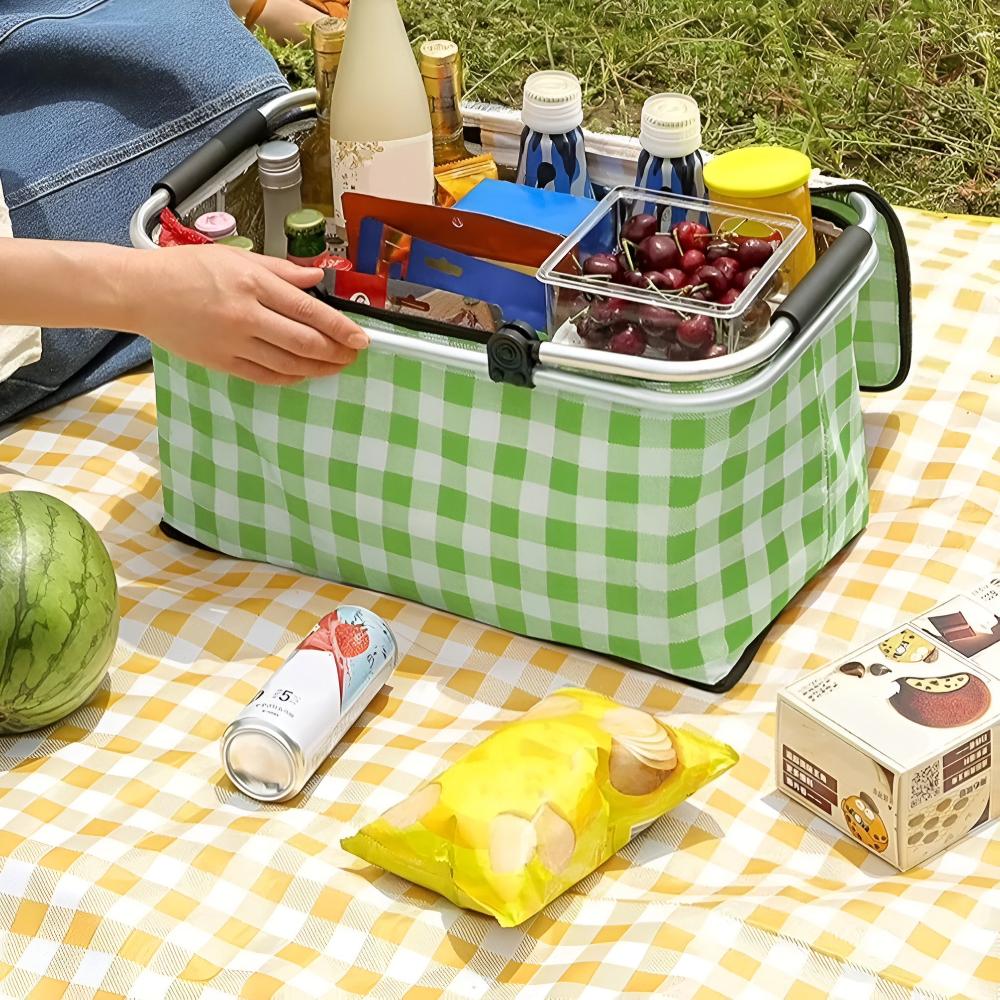 Green checkered insulated picnic basket filled with food and drinks, placed on a yellow checkered blanket.