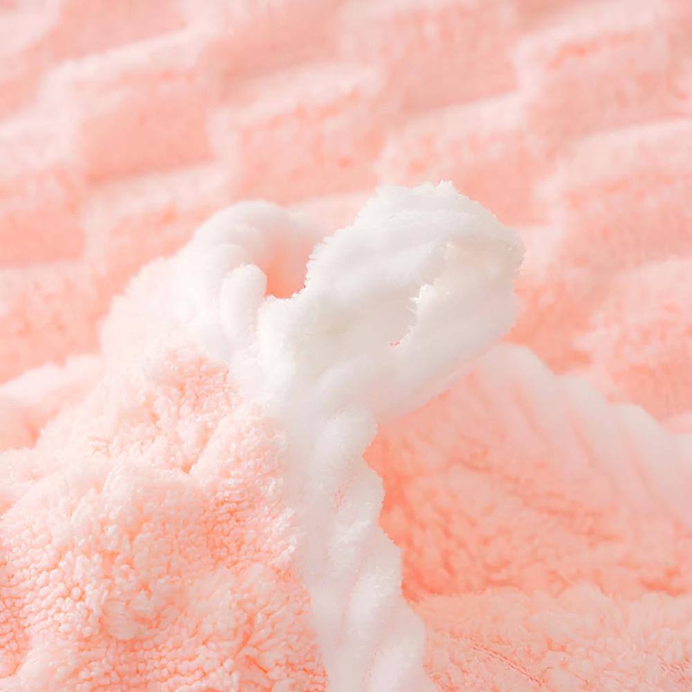 Close-up of a soft, pink fleece towel with a white textured edge.