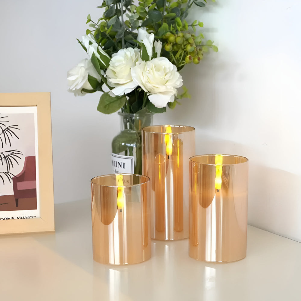 Three amber glass flameless candles with 3D LED flames on a white surface.