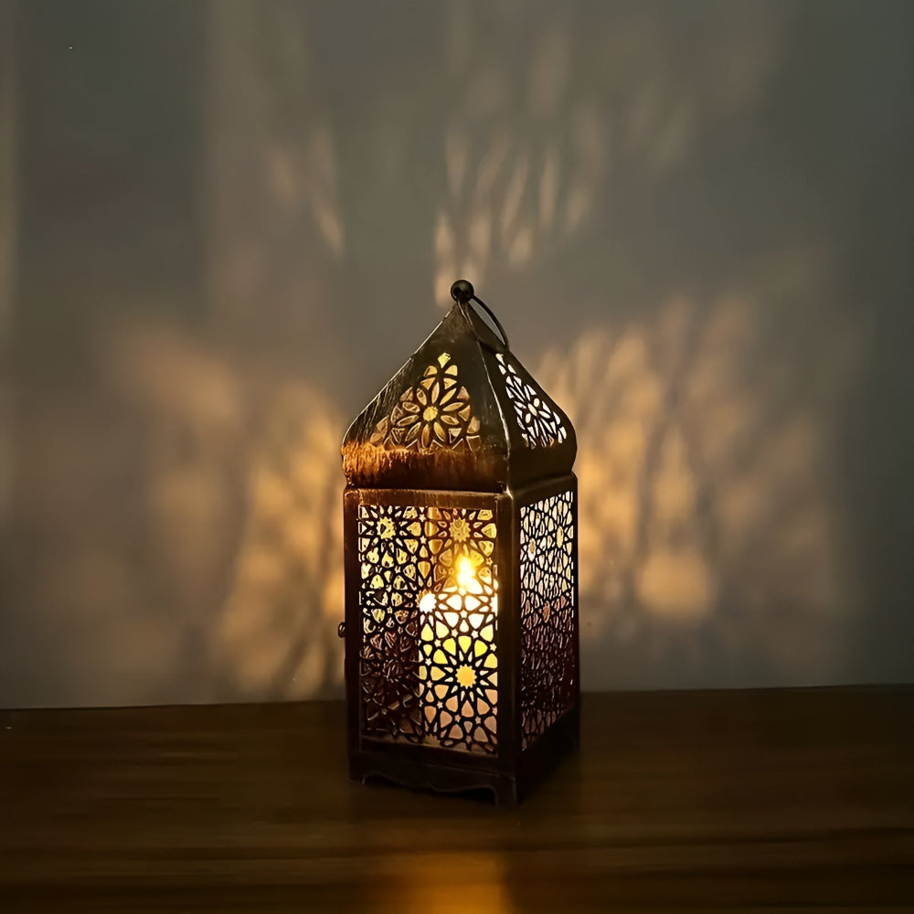 Antique iron candle holder with intricate Middle Eastern-inspired metalwork, casting a warm glow.