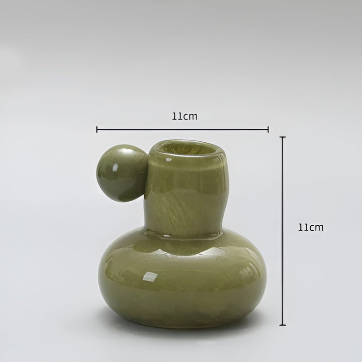 Green glass candle holder with a round ball accent, 11cm wide and 11cm tall.