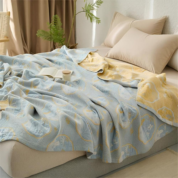 Reversible blanket with a light blue side featuring a floral pattern and a yellow side.