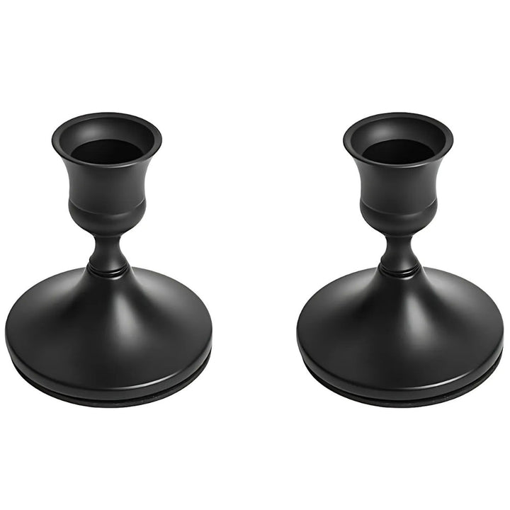 Two black vintage taper candle holders with wide bases and fluted cups.