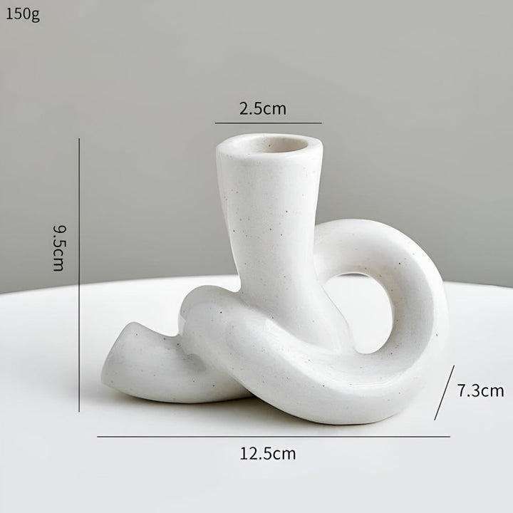 White ceramic knot candle holder, 9.5cm tall, 12.5cm wide, 7.3cm base, 2.5cm opening.