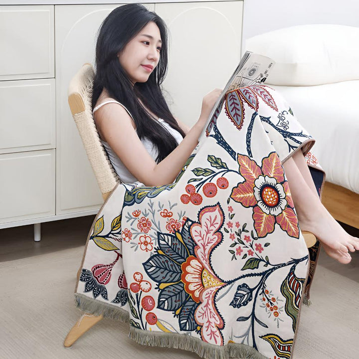 Woman sitting in a chair wrapped in a reversible cotton bath towel with a vibrant floral print.