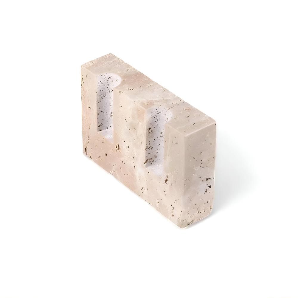 Travertine stone candle stand with two slots for taper candles, on a white background.