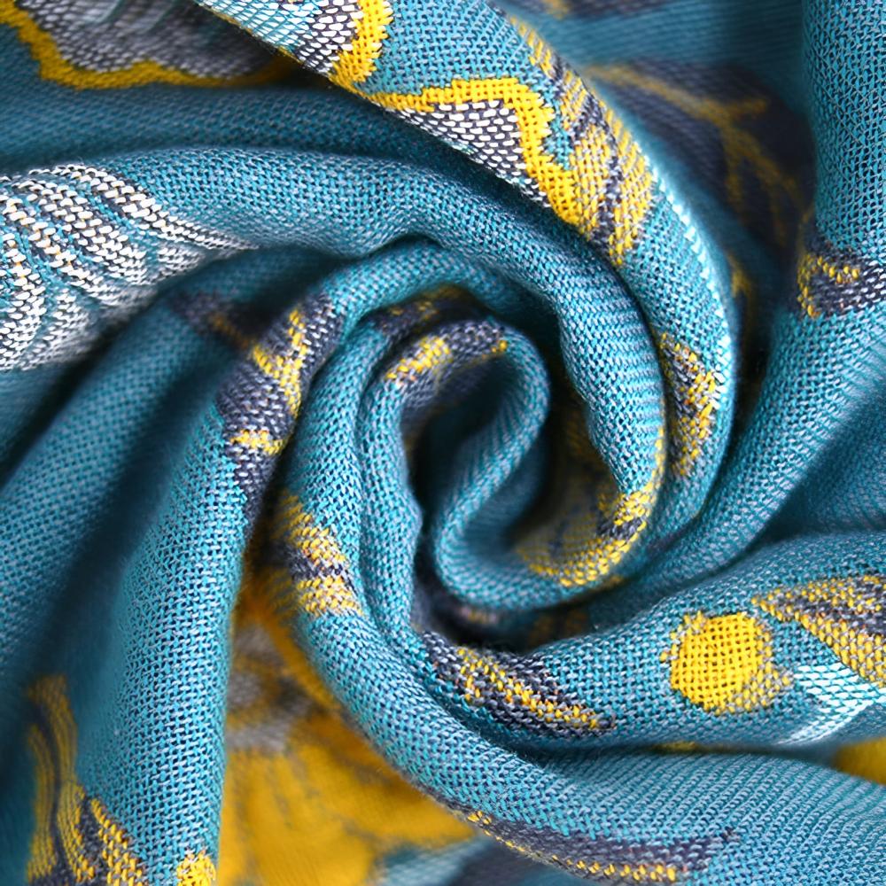 Close-up of a rolled blue and yellow hibiscus patterned cotton towel.