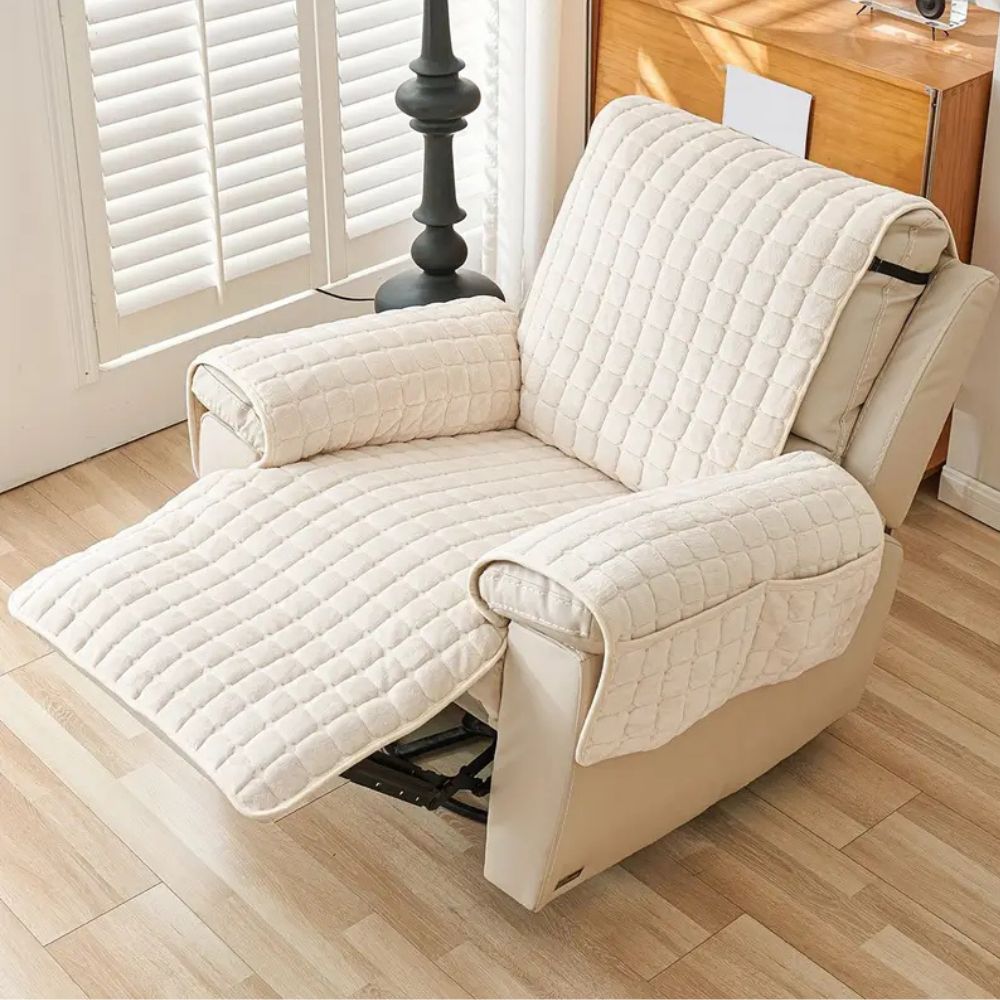 Cream quilted recliner chair cover with armrest pockets and footrest extension.