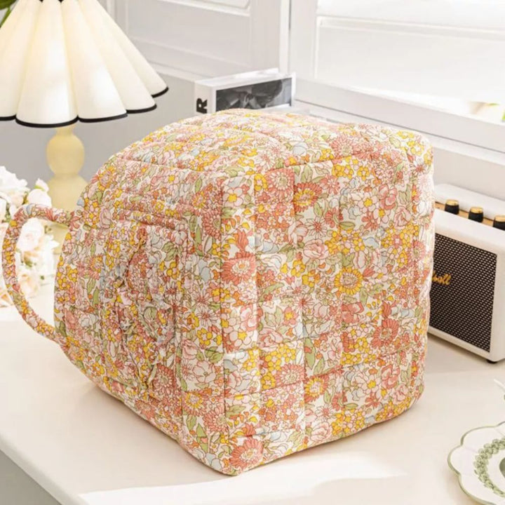 Quilted canvas storage basket with a delicate floral pattern and a handle.