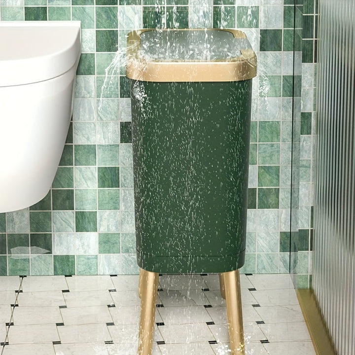 Dark green 15L elevated trash can with gold legs and lid, with water splashing on it.