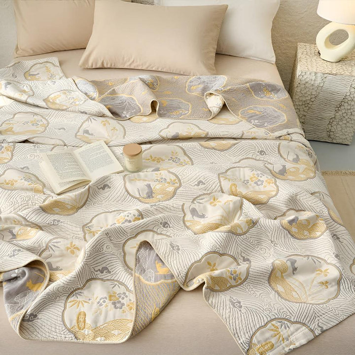 Reversible blanket with a Japanese-inspired cloud and wave pattern in beige, grey, and gold.