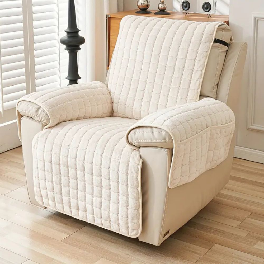 Cream quilted recliner chair cover with side pockets, protecting a beige recliner.