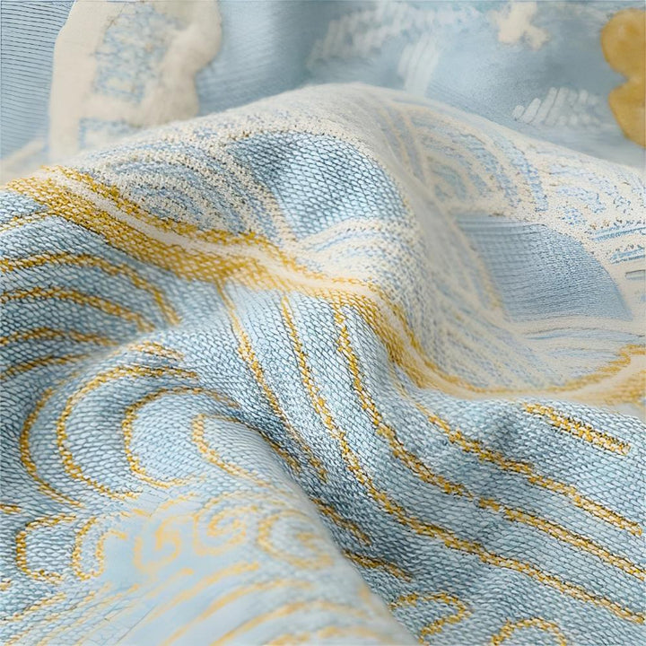 Light blue blanket with a textured wave pattern in yellow and white.
