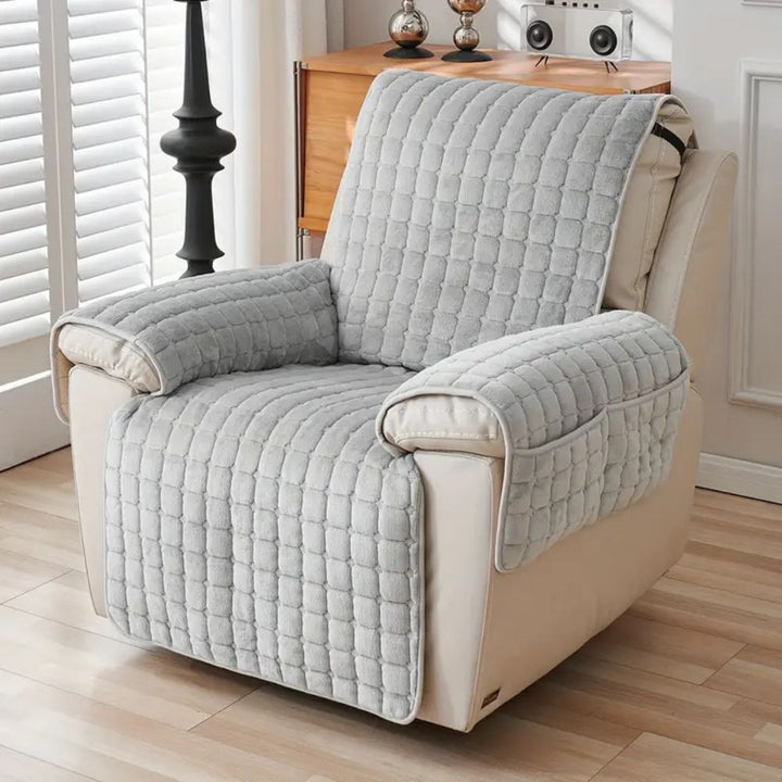Gray quilted microfiber recliner chair cover with side pockets.