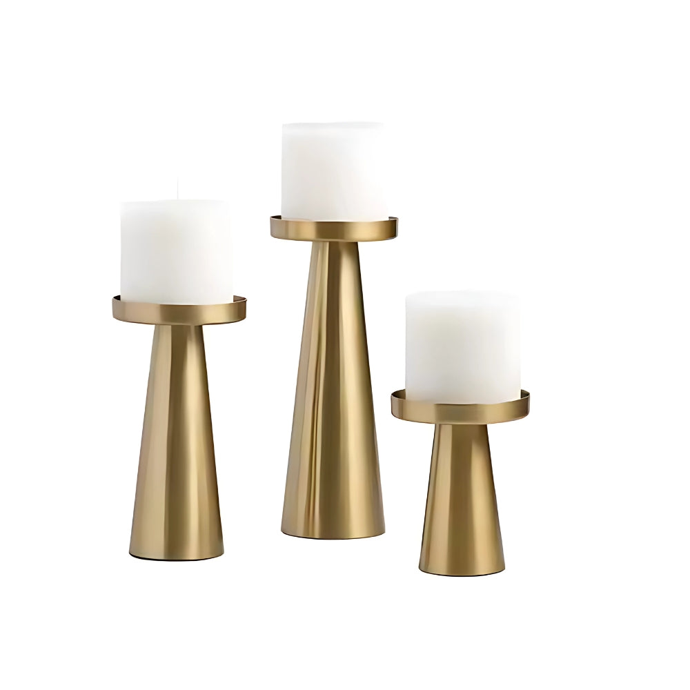 Set of three artisan brass candle holders in varying sizes on a white background.