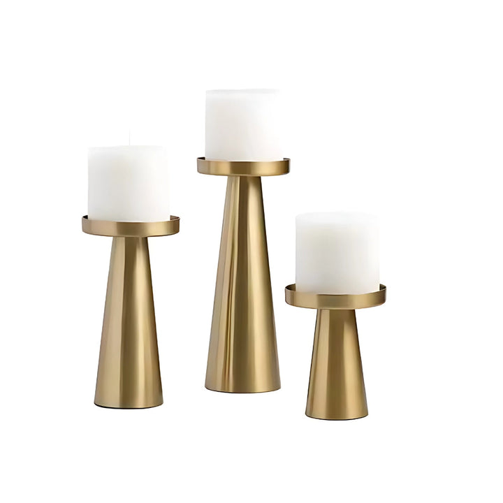Set of three artisan brass candle holders in varying sizes on a white background.