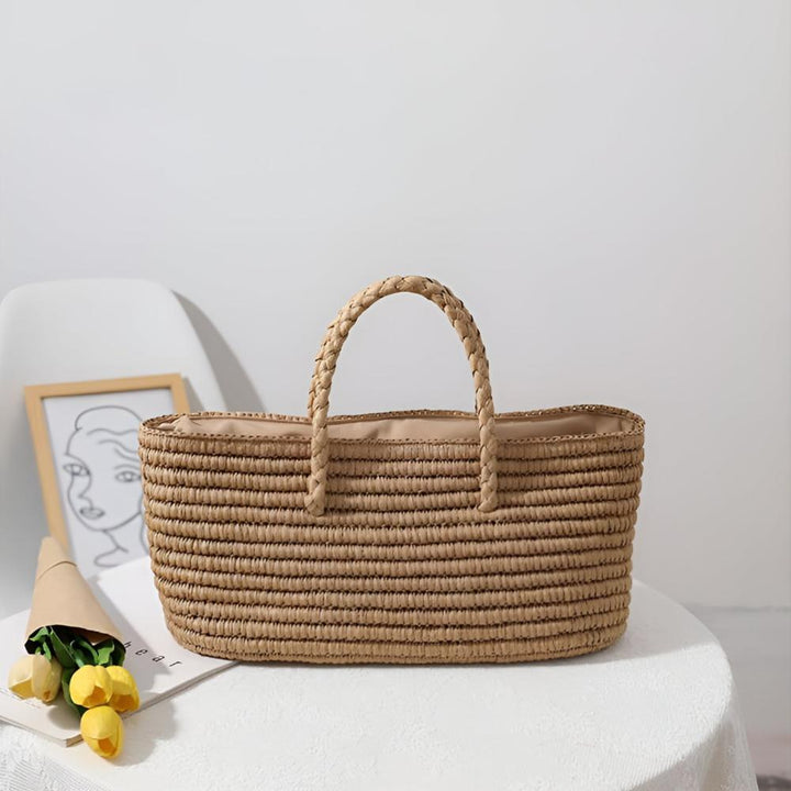 Handwoven straw tote bag with braided handles and a beige interior.
