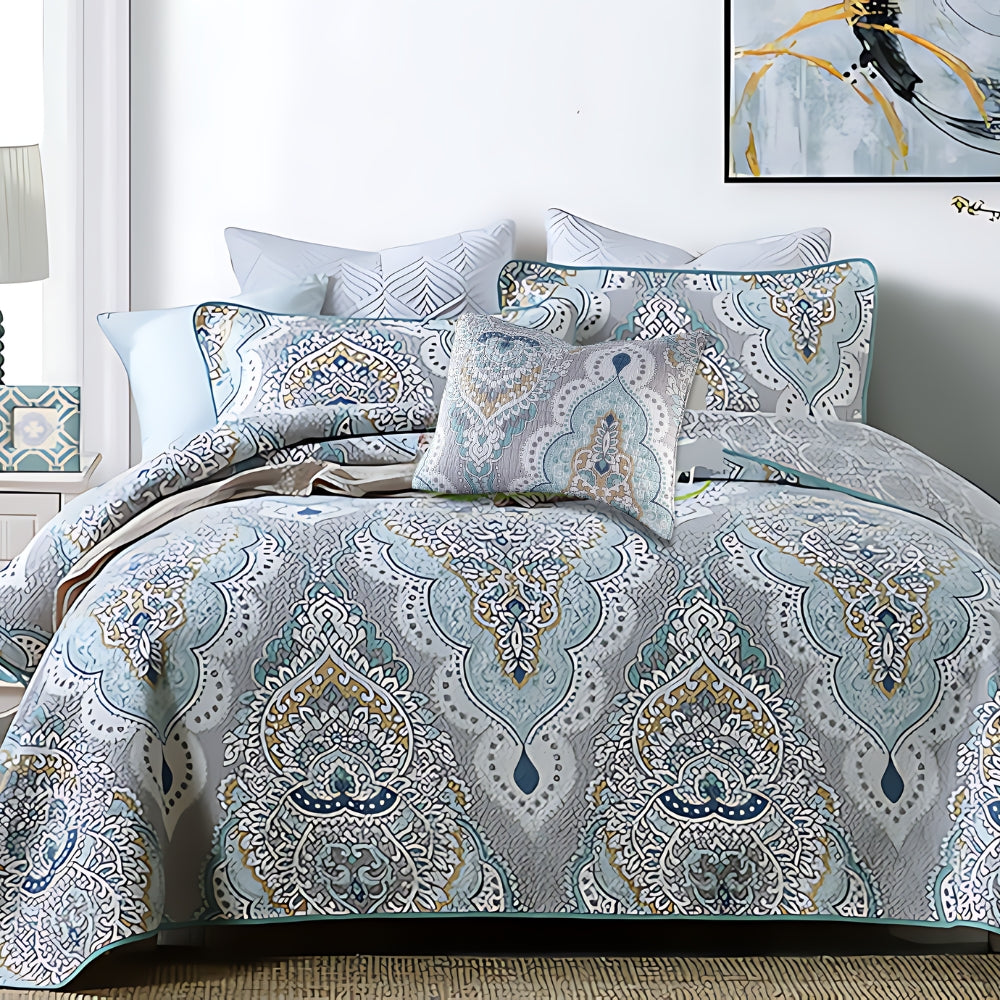 Paisley aqua teal coverlet set with decorative pillows on a bed.