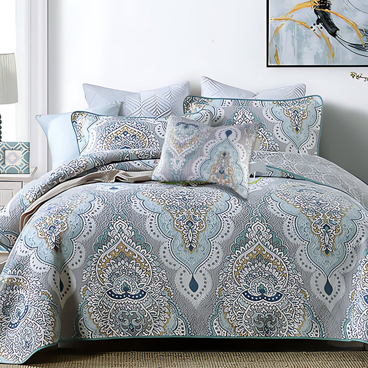 Paisley aqua teal coverlet set with decorative pillows on a bed.