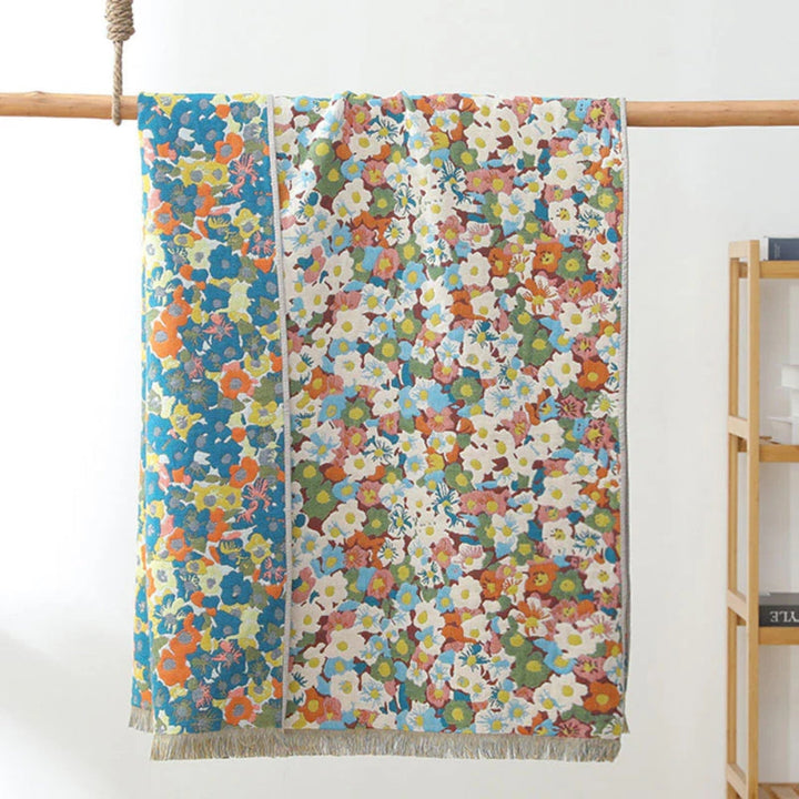 Reversible cotton bath towel with a vibrant floral print on both sides, featuring a fringed edge.