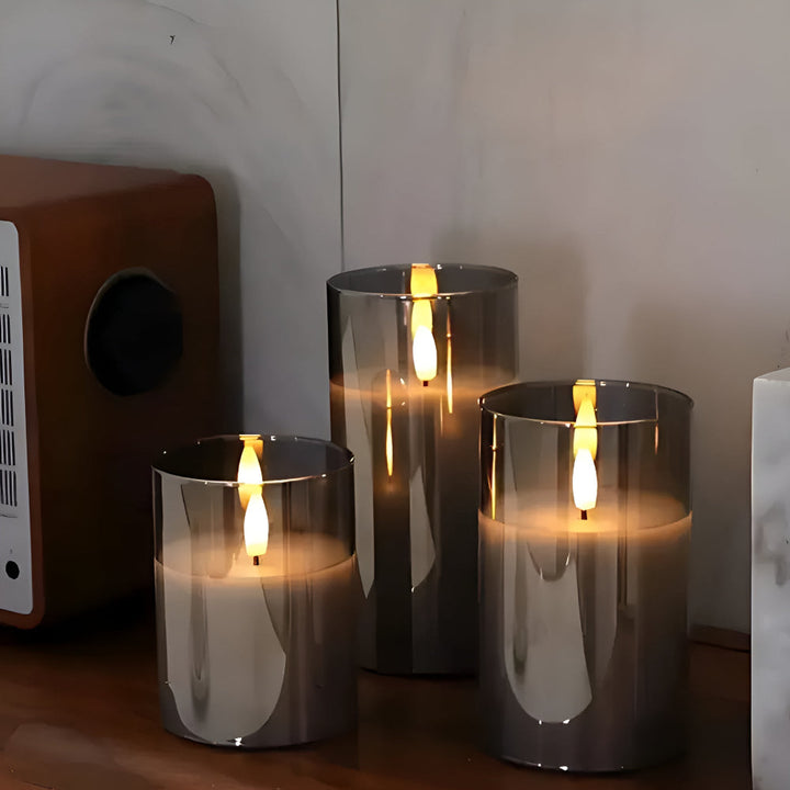 Three grey glass flameless candles with realistic 3D LED flames on a wooden surface.