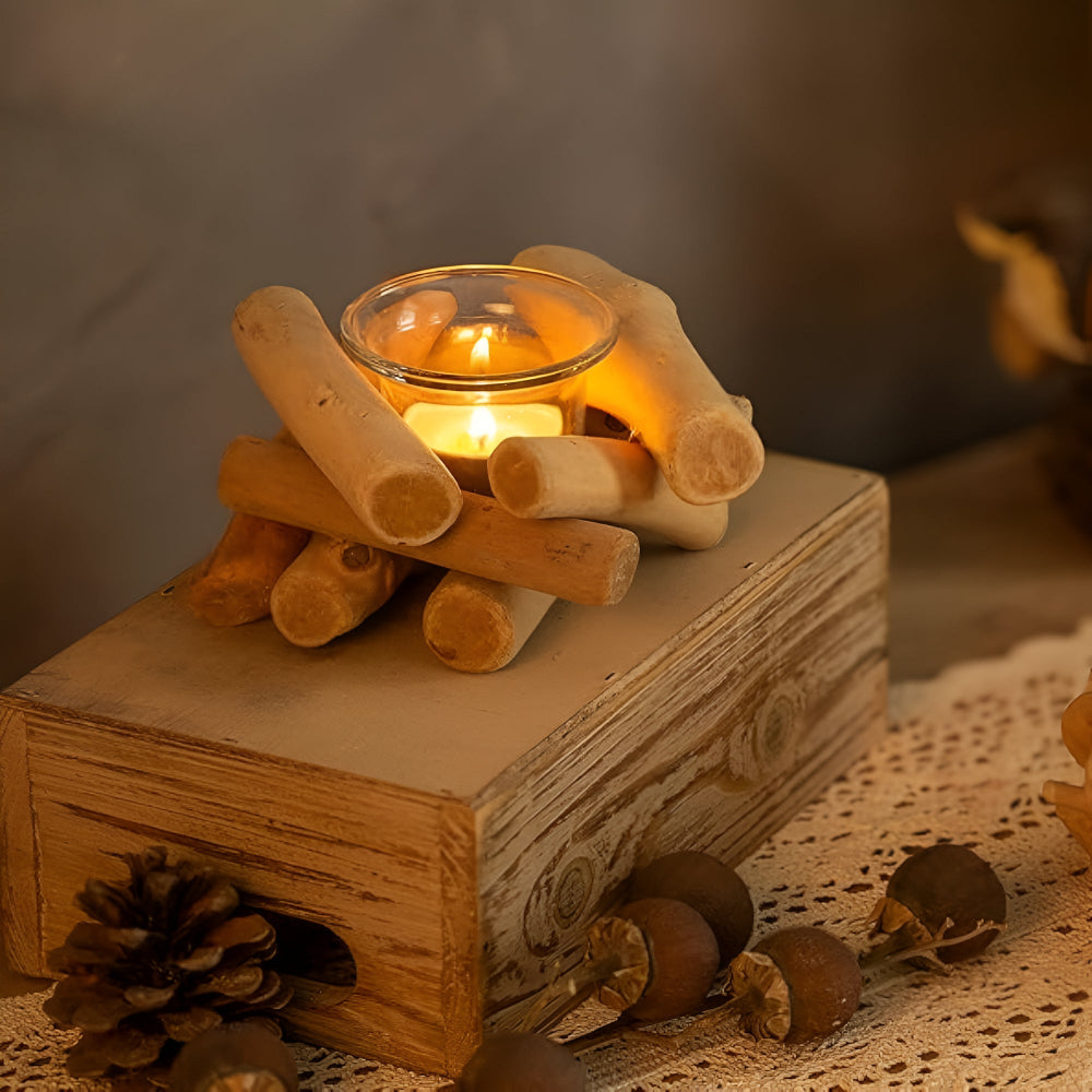 Driftwood tealight holder with a lit candle on a rustic wooden box.