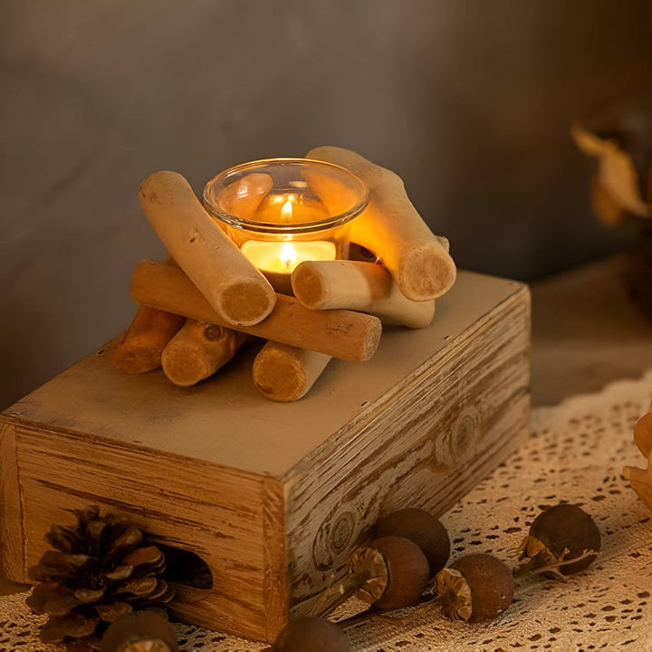 Driftwood tealight holder with a lit candle on a rustic wooden box.