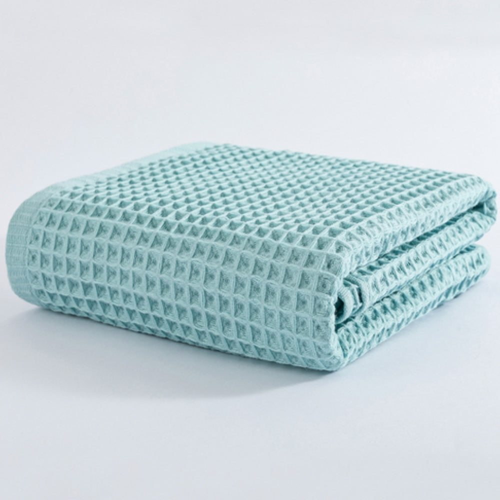 Light blue cotton waffle bath towel folded on a white background.