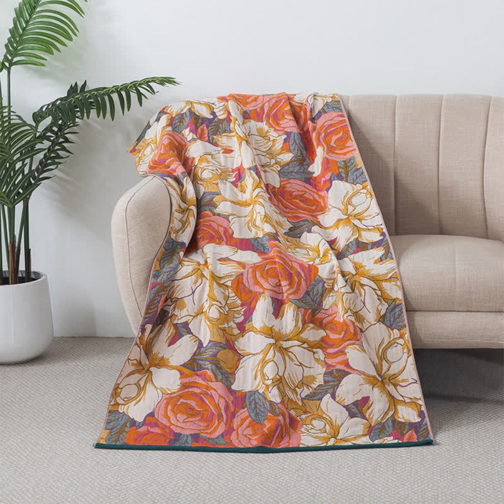A soft cotton bath towel with a vintage rose floral design in coral orange and white.