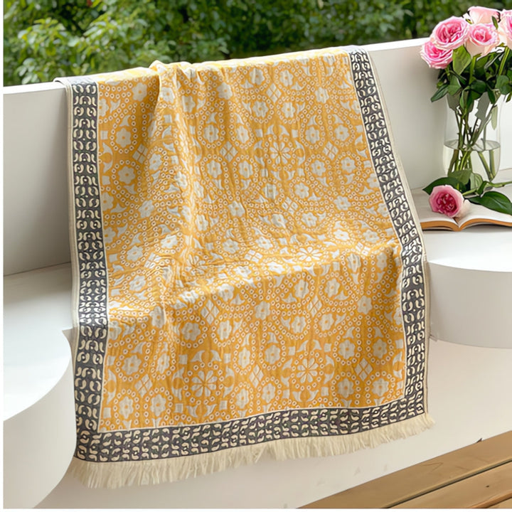 Yellow pure cotton bath towel with a white and gray geometric pattern and fringe.