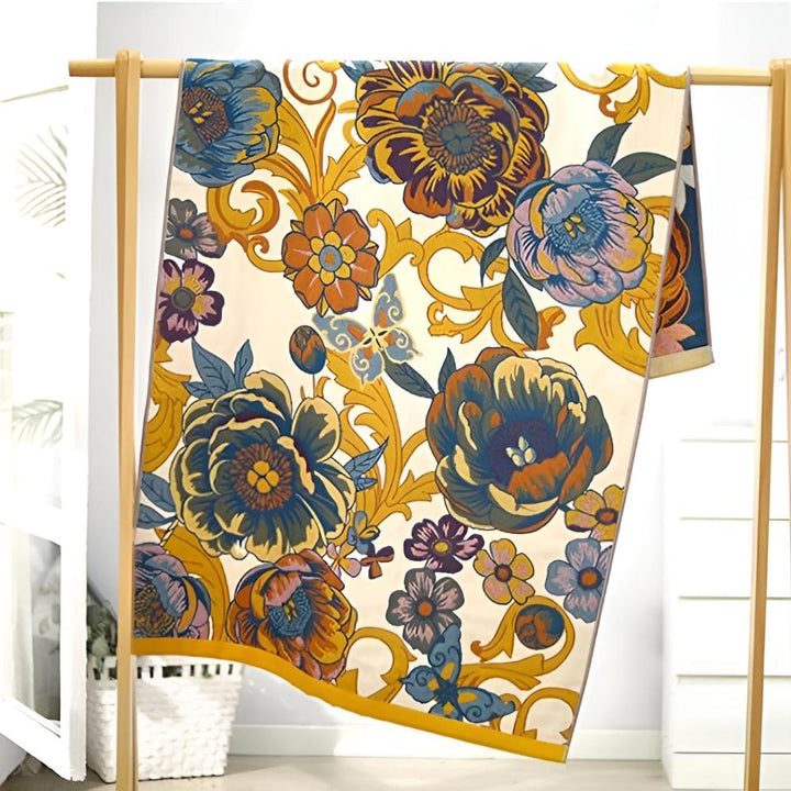 Reversible cotton bath towel with a bold, colorful floral and butterfly pattern in blue, orange, and yellow.