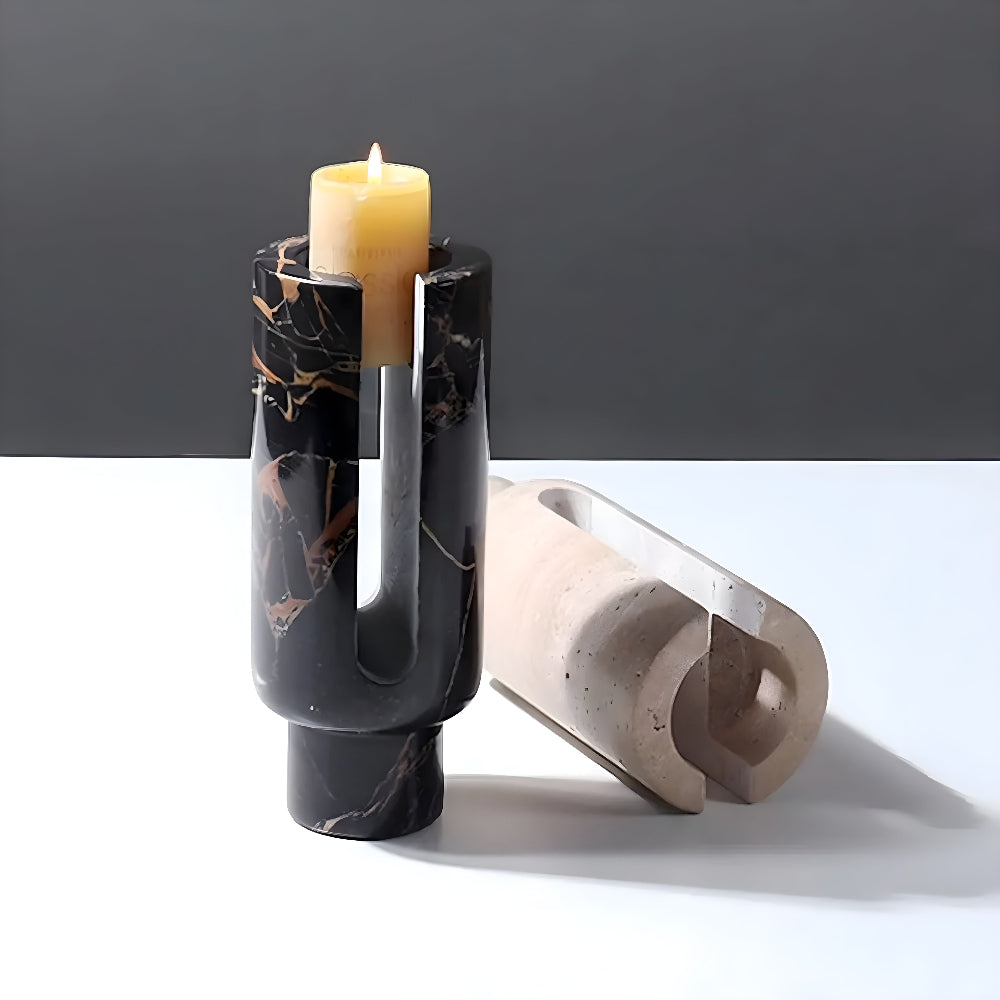 Black marble candle holder with a lit candle and a beige ceramic holder.