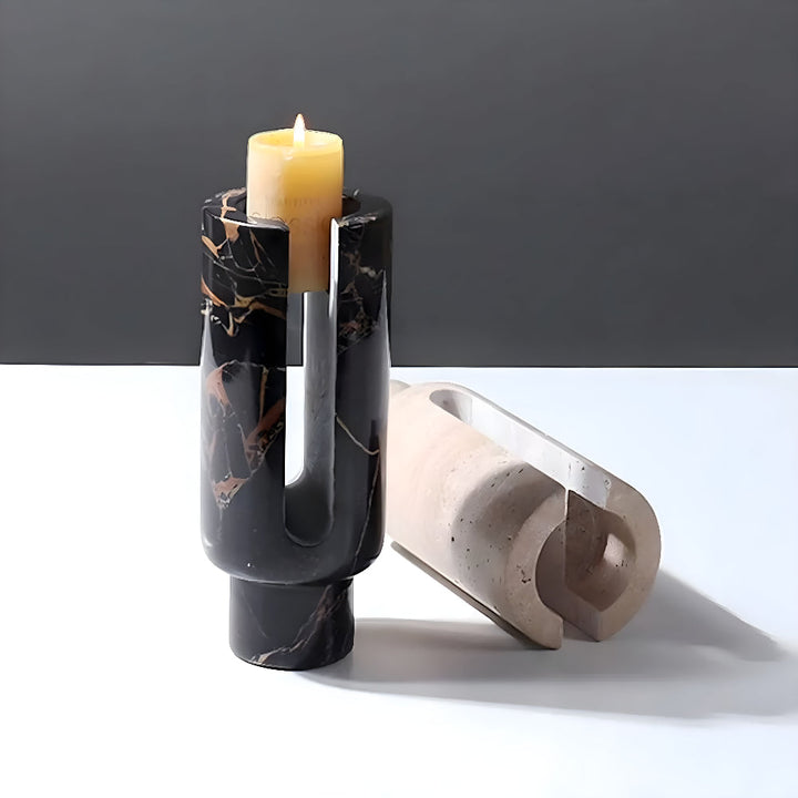 Black marble candle holder with a lit candle and a beige ceramic holder.