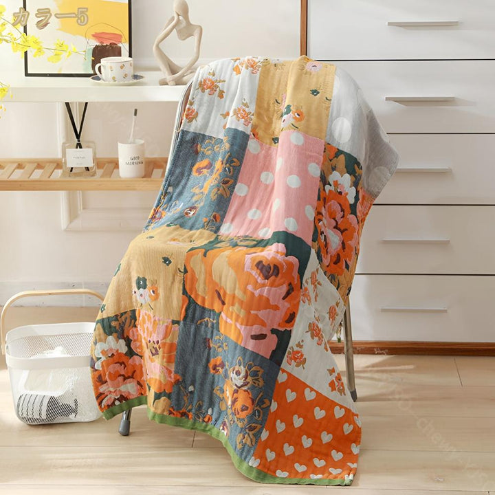 Patchwork cotton bath towel with floral, polka dot, and heart prints draped over a chair.