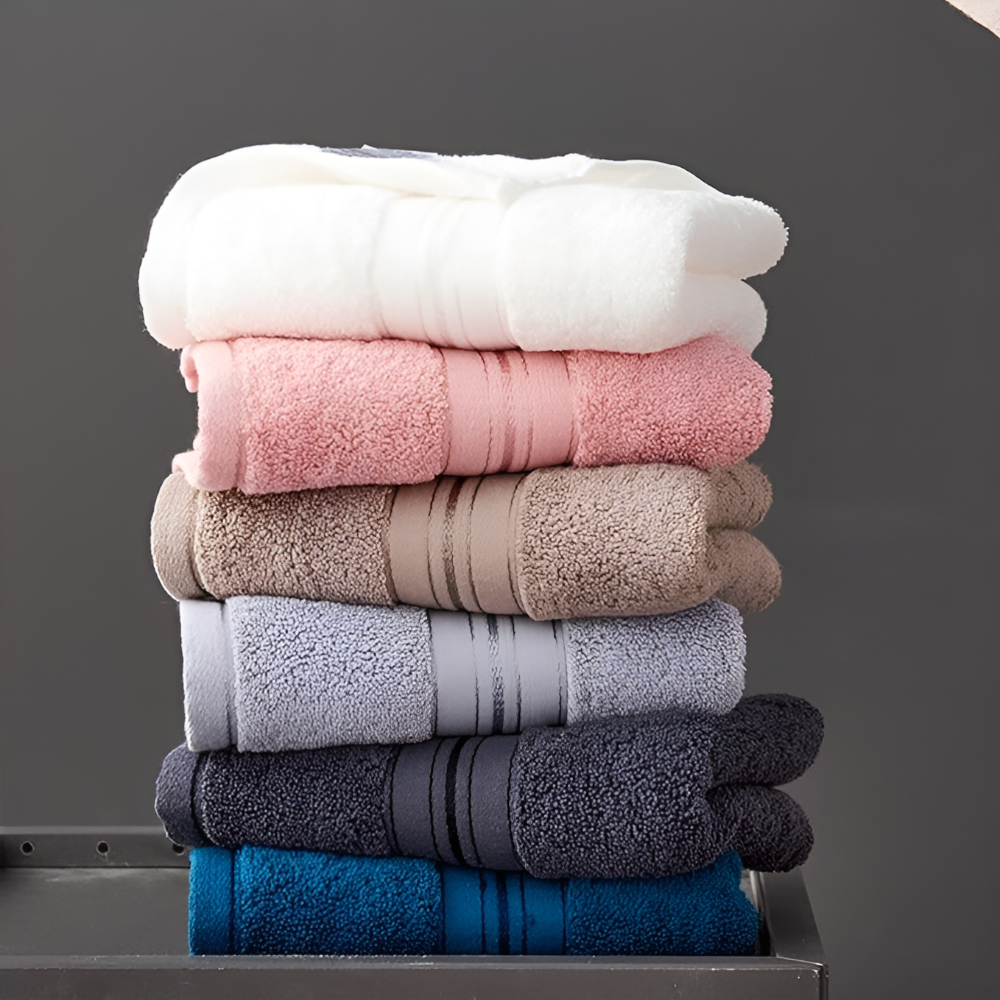 Stack of six Egyptian cotton towels in various colors: white, pink, beige, light blue, dark blue, and charcoal.