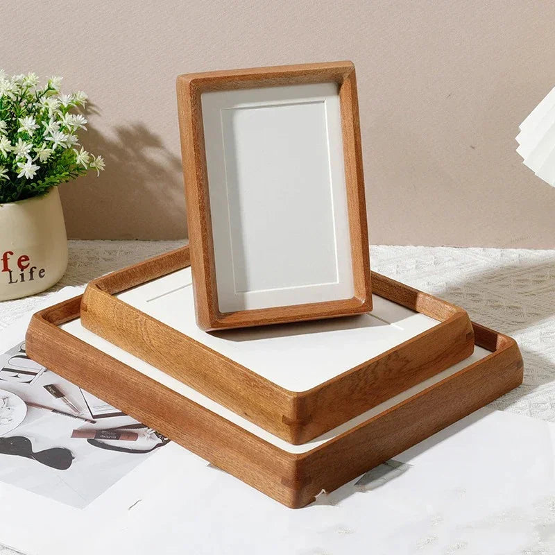 Two handcrafted solid wood photo frames, one standing vertically on a larger tray frame.
