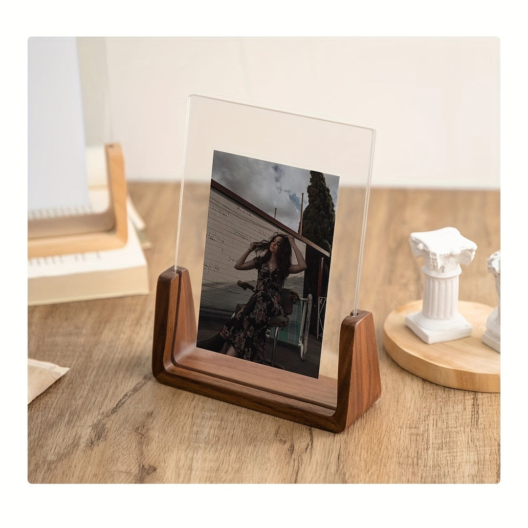 U-shaped acrylic photo frame with a photo of a woman, on a wooden desk.