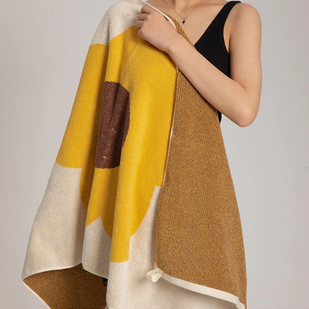 Woman holding a yellow and cream floral cotton bath towel with a brown center.