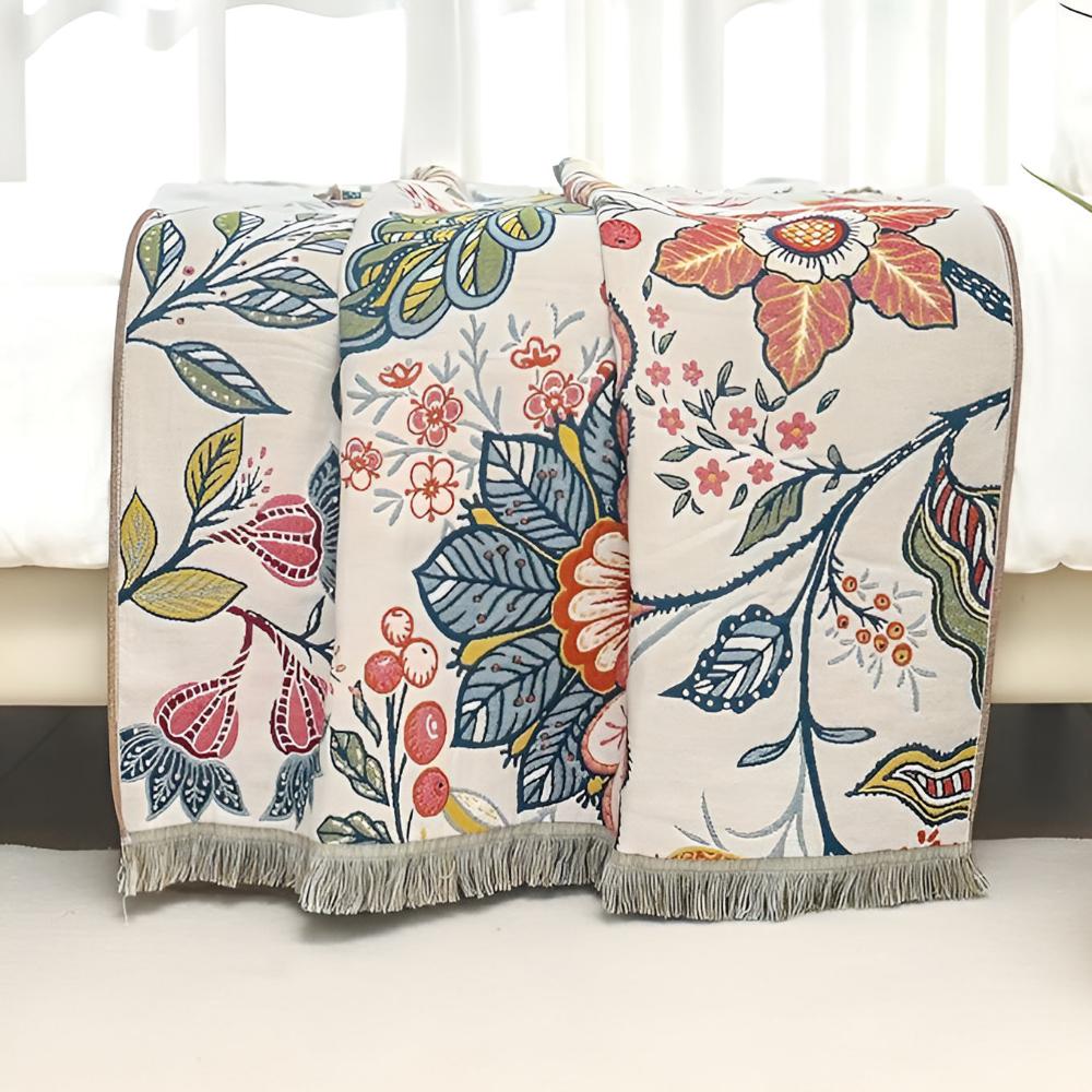 Three reversible cotton bath towels with a vibrant floral print and fringed edges.