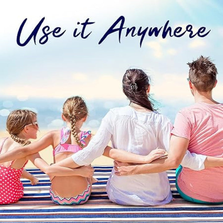 Family sitting on a waterproof picnic mat at the beach. Text overlay: Use it Anywhere.
