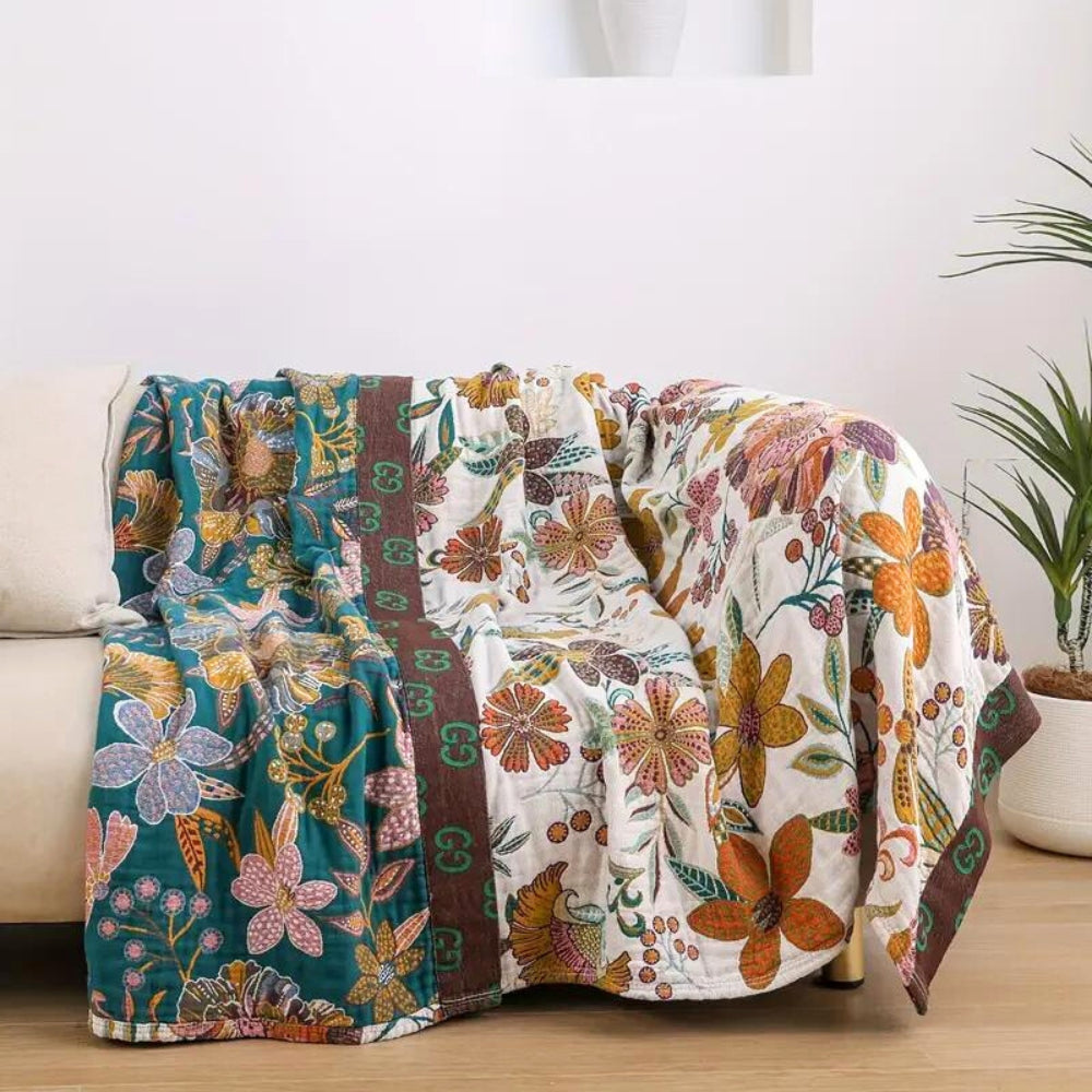 Charm floral blanket throw with teal and white floral patterns and a brown border.
