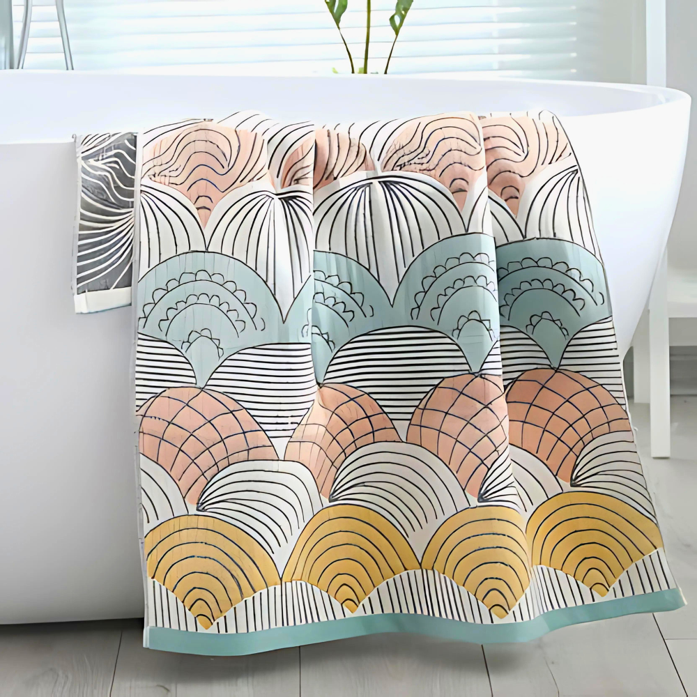 A cotton bath towel with a colorful shell-inspired jacquard weave draped over a white bathtub.