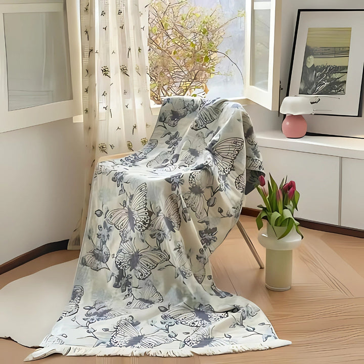 A soft, pure cotton bath towel featuring a decorative butterfly pattern draped over a chair.