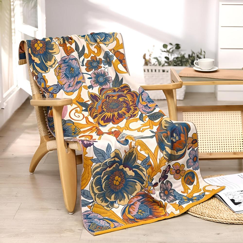Reversible cotton bath towel with a vibrant blooming floral pattern draped over a wooden chair.