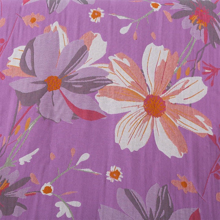Cotton gauze bath towel with a floral pattern on a purple background.