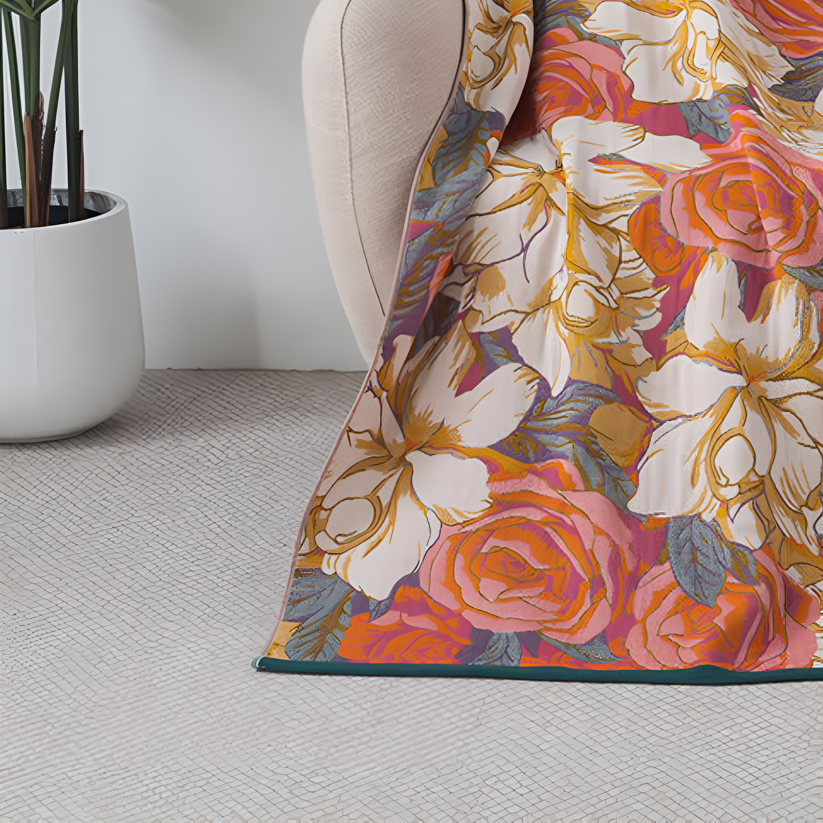 A close-up of a cotton gauze bath towel with a vibrant floral rose pattern draped over a chair.