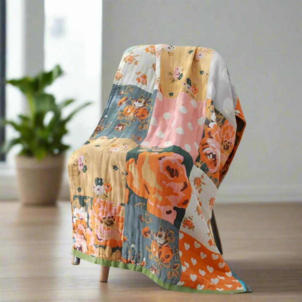Patchwork quilt with floral and polka dot patterns draped over a chair.