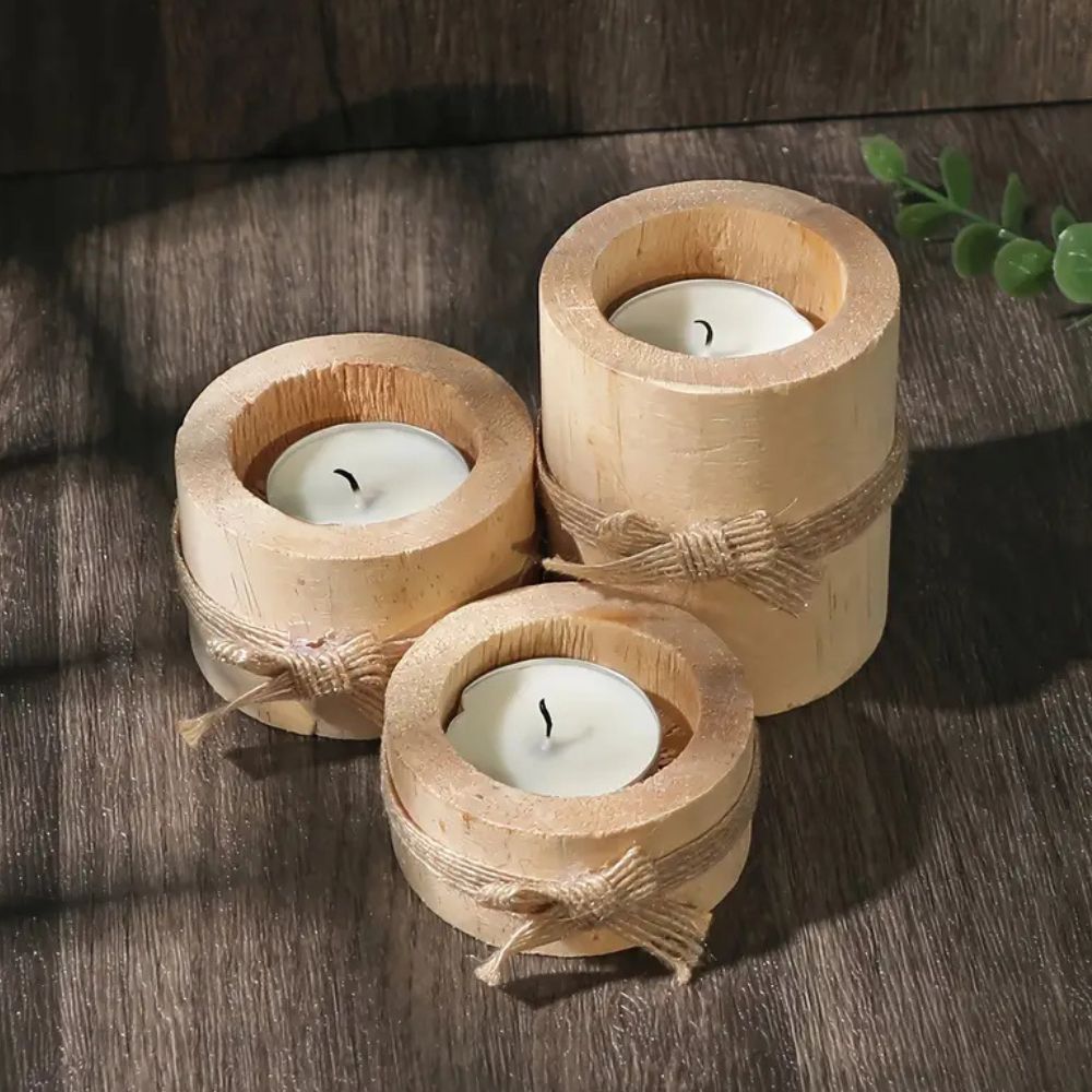 Set of 3 handcrafted bamboo candle holders with tea lights on a wooden surface.