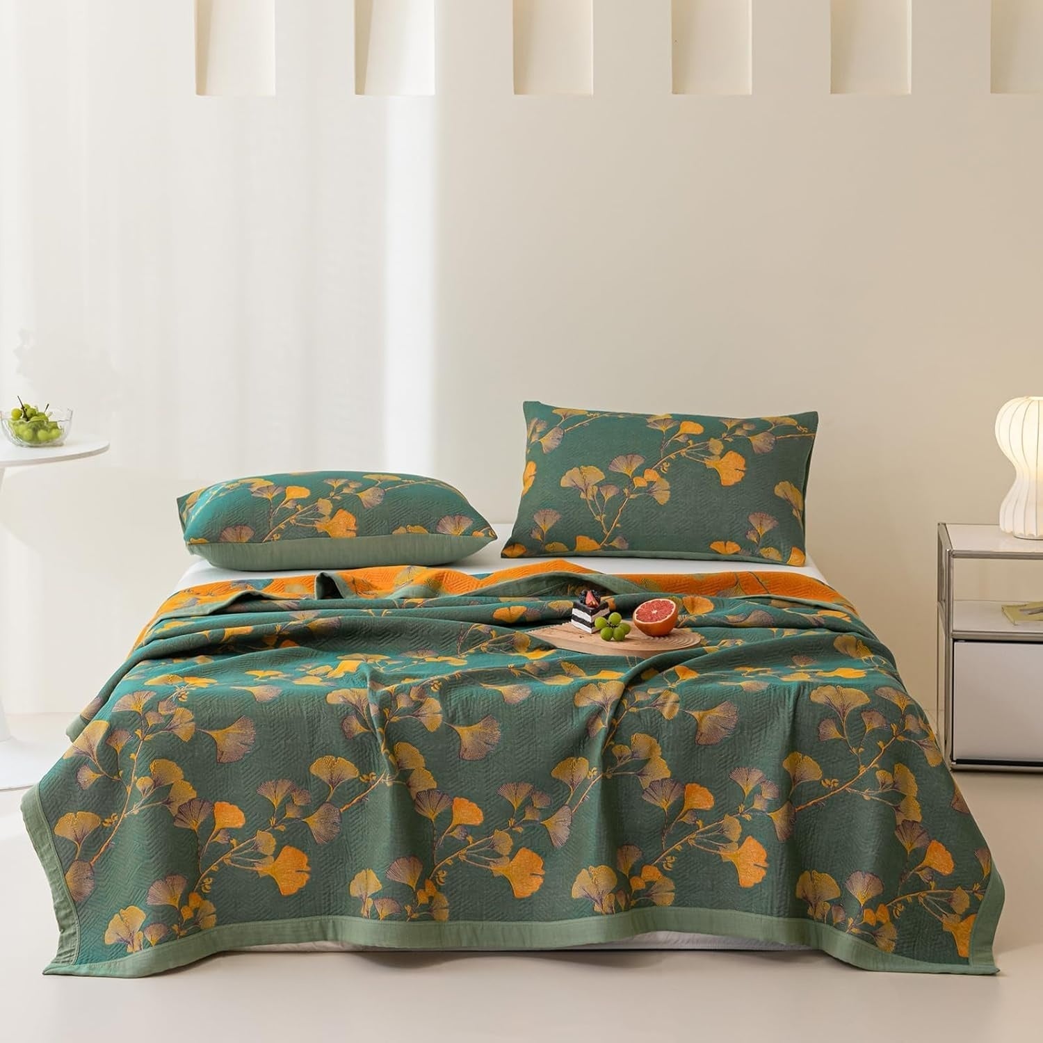 Green reversible coverlet with a repeating pattern of yellow and grey ginkgo leaves.